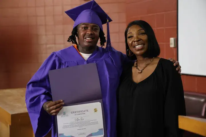 Graduate holding her achievement certificate