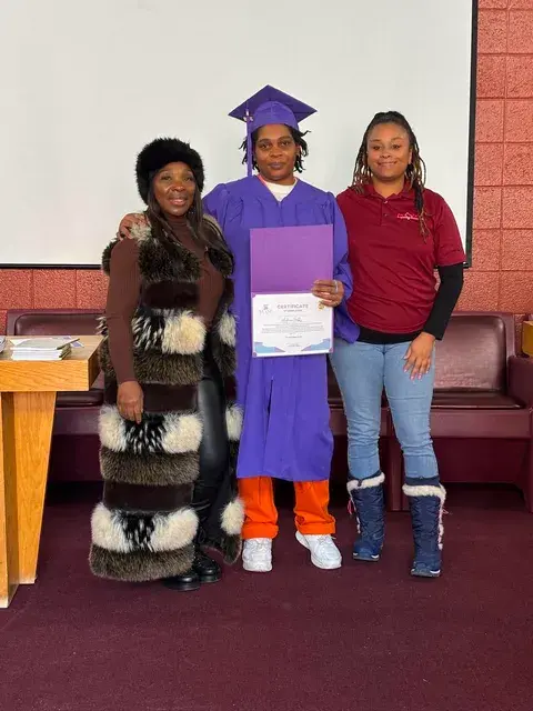 Graduate posing with family and supporters